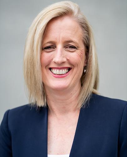 Colour photo of the Minister for Finance, Senator the Hon Katy Gallagher, wearing a blue blazer. 