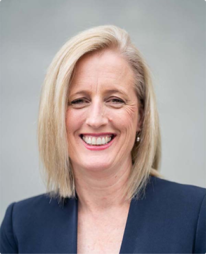 Colour head shot of Katy Gallagher, current Minister for Finance. She is smiling and wearing a blue blazer. 