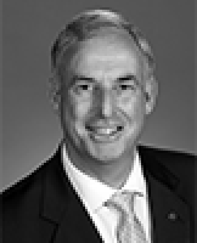 Black and white head shot of Richard Colbeck, former Parliamentary Secretary to the Minister for Finance and Administration. He is smiling and wearing a dark suit jacket, white shirt and a tie.