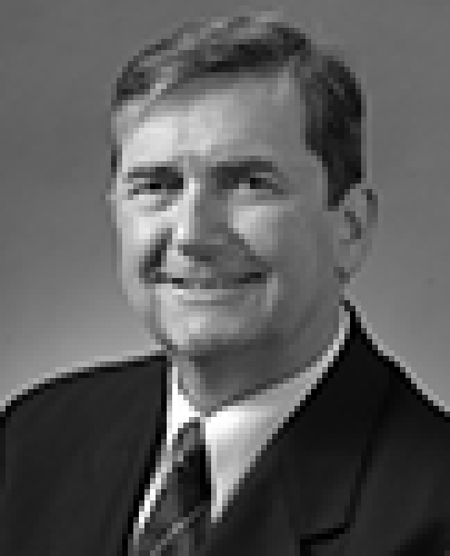 Black and white head shot of Chris Ellison, former Special Minister of State. He is smiling broadly and is wearing a dark suit jacket, white shirt and a tie.