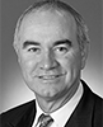Black and white head shot of Gary Nairn, former Special Minister of State. He is smiling and wearing a dark jacket, white shirt and striped tie.