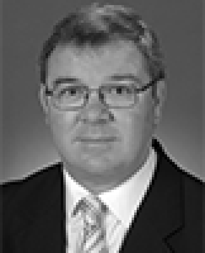 Black and white head shot of Gary Gray, former Special Minister of State. He is wearing a dark suit jacket, white shirt and a tie. 
