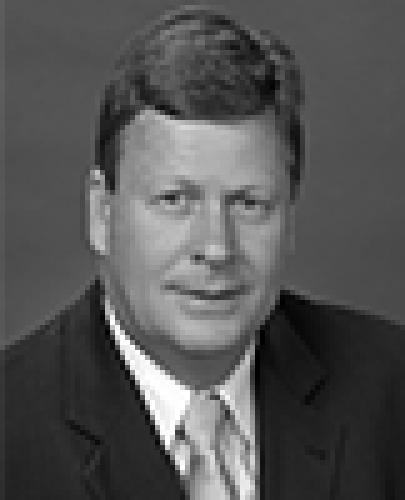 Black and white head shot of Michael Ronaldson, former Special Minister of State. He is wearing a dark suit jacket, white shirt and tie.