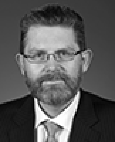 Black and white head shot of Scott Ryan, former Special Minister of State. He has a beard and is wearing glasses, a dark suit, shirt and tie.