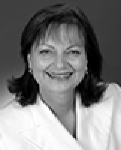 Black and white head shot of Dr Sharman Stone, former Parliamentary Secretary to the Minister for Finance and Administration. She is smiling broadly and wearing a white blazer.