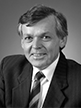 Black and white head shot of John Dawkins, former Minister for Finance. Black and white head shot of Peter Walsh, former Minister for Finance. He is smiling and wearing a dark jacket, shirt, and tie. 